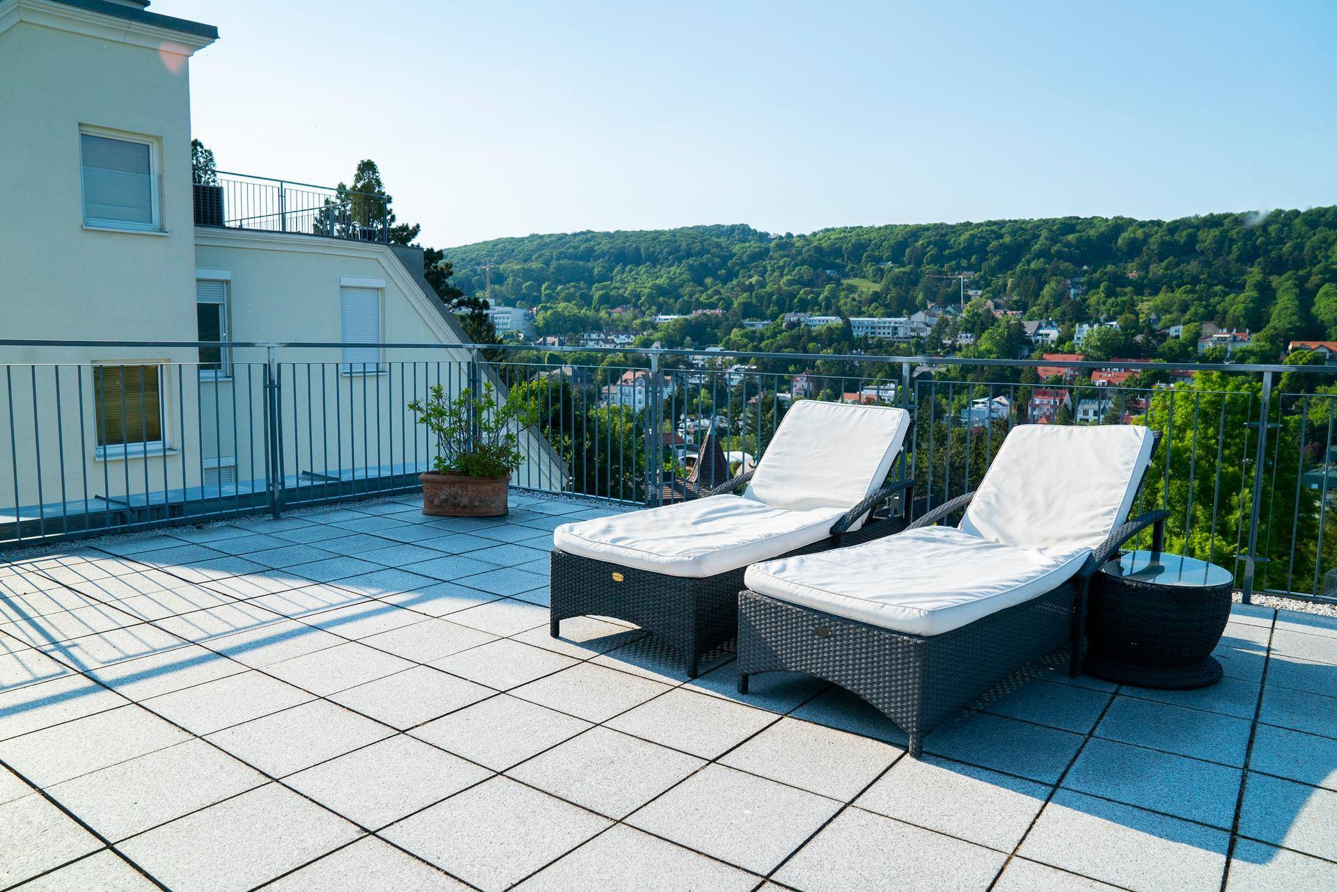 Geräumige Dachterrasse mit Liegestühlen und weitem Blick über die grüne Hügellandschaft.