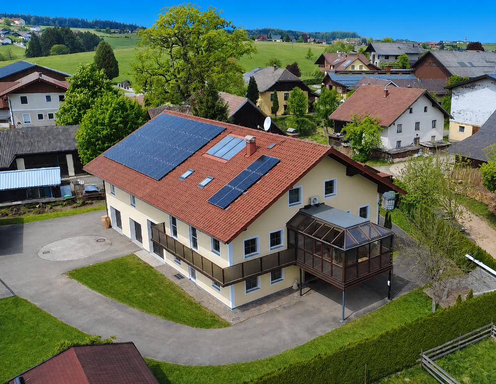 Luftaufnahme des Wohnhauses mit Solaranlagen auf dem Dach und ländlicher Umgebung.