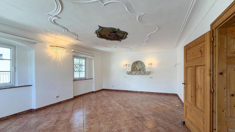 Geräumiger Raum mit Stuckdecke, Terrakottafliesen und dekorativer Wandnische.
