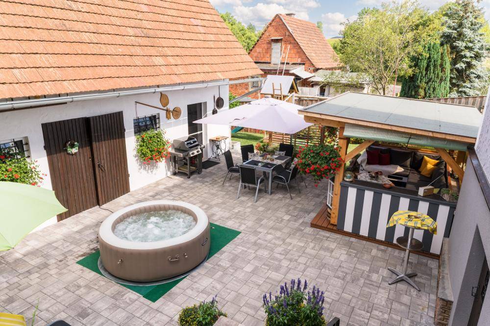 Gemütlicher Innenhof mit Whirlpool, Essbereich und überdachter Lounge-Ecke.