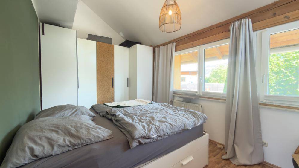 Schlafzimmer im Dachgeschoss mit Doppelbett, Einbauschränken und Holzbalken.