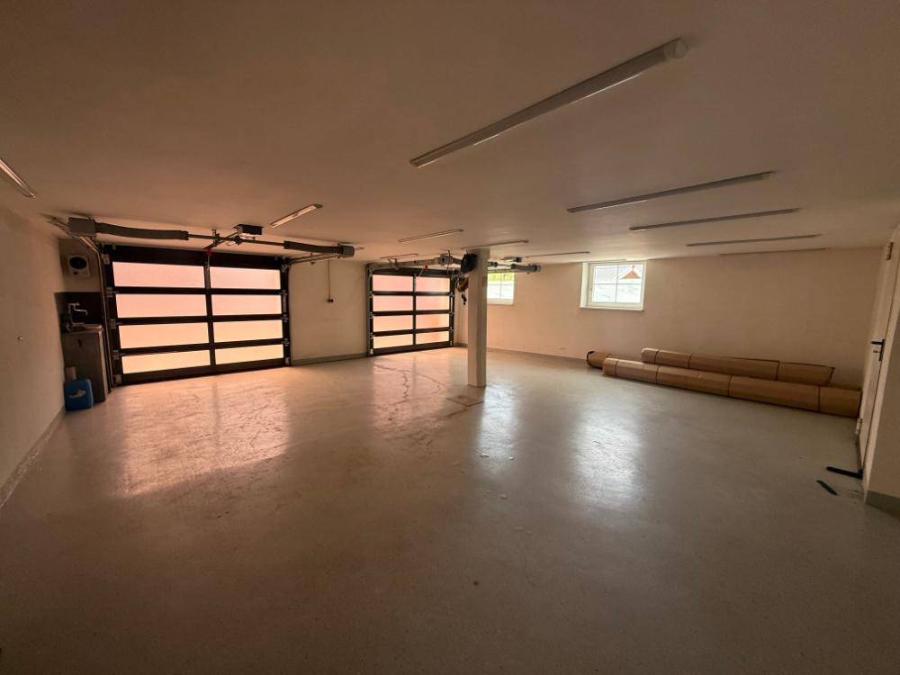 Große Garage mit zwei Toren, Fenstern und viel Platz.