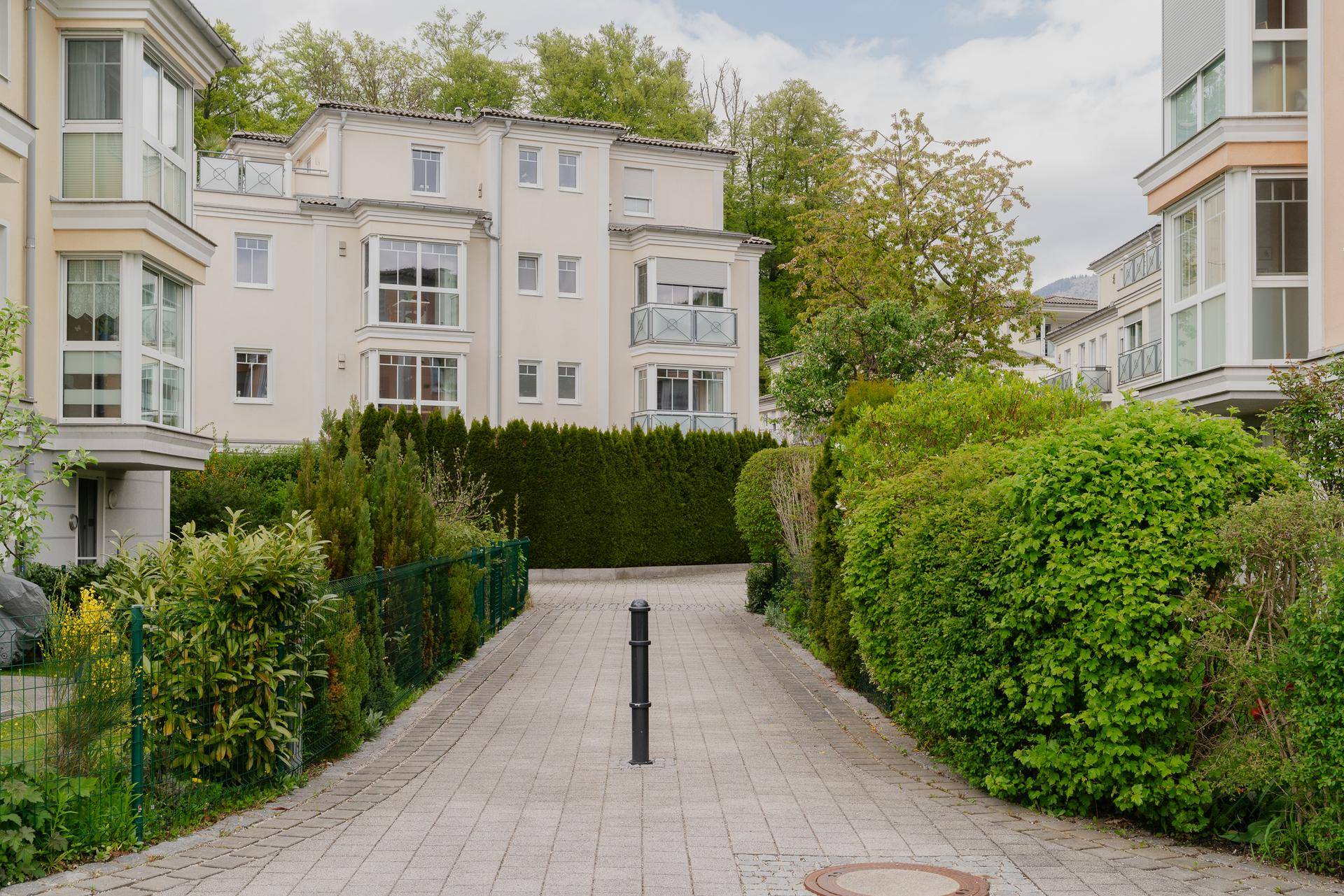 Gepflegte Außenanlage der Wohnanlage mit Gehwegen und grünen Hecken.