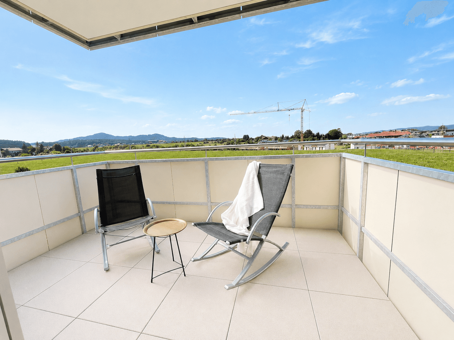 Geräumiger Balkon mit Fliesenboden, Sitzgelegenheiten und weitem Blick ins Grüne.