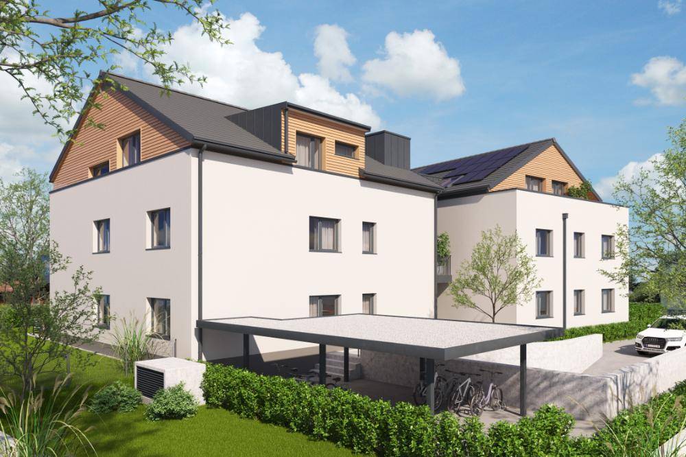 Moderne Wohnanlage von der Rückseite mit Carport, Fahrradstellplätzen und Solarpaneelen auf dem Dach.