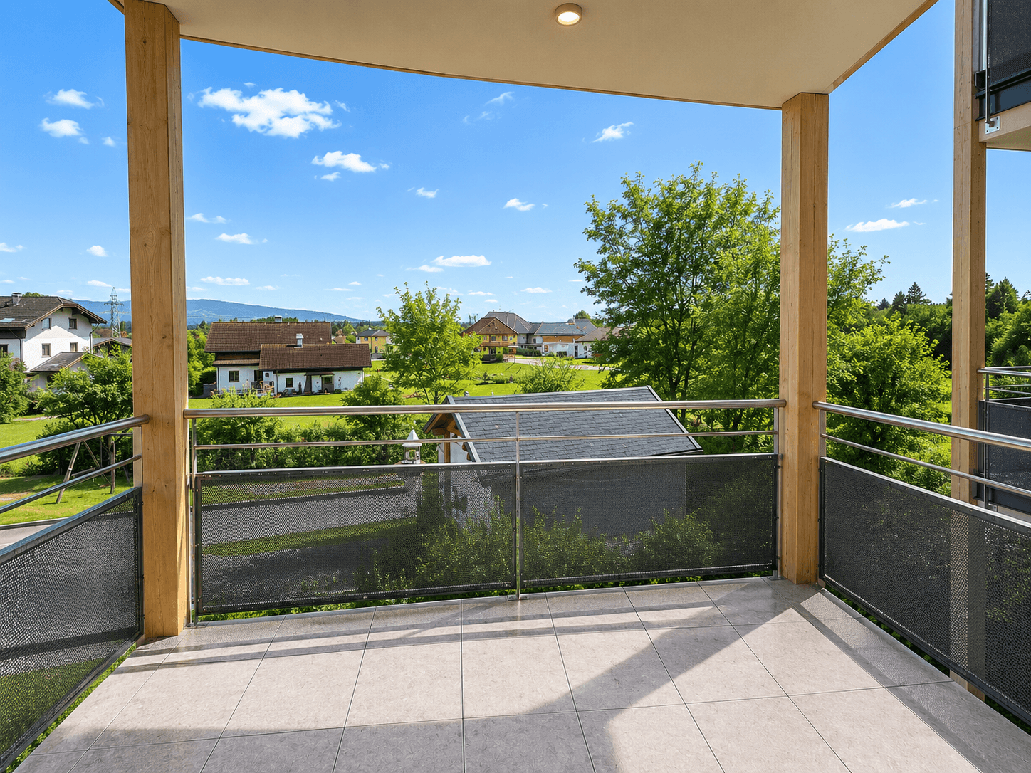 Geräumiger Balkon mit Fliesenboden und weitem Blick über die umliegende Landschaft.