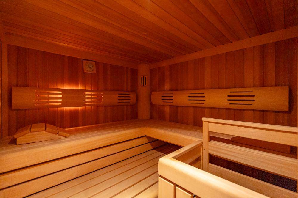 Moderne Holzsauna mit bequemen Bänken und stimmungsvoller Beleuchtung für Entspannung.