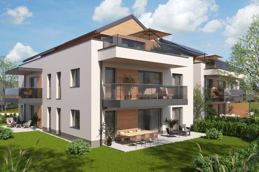 Moderne Wohnanlage mit Balkonen, Terrassen und Gartenbereichen, umgeben von viel Grün.