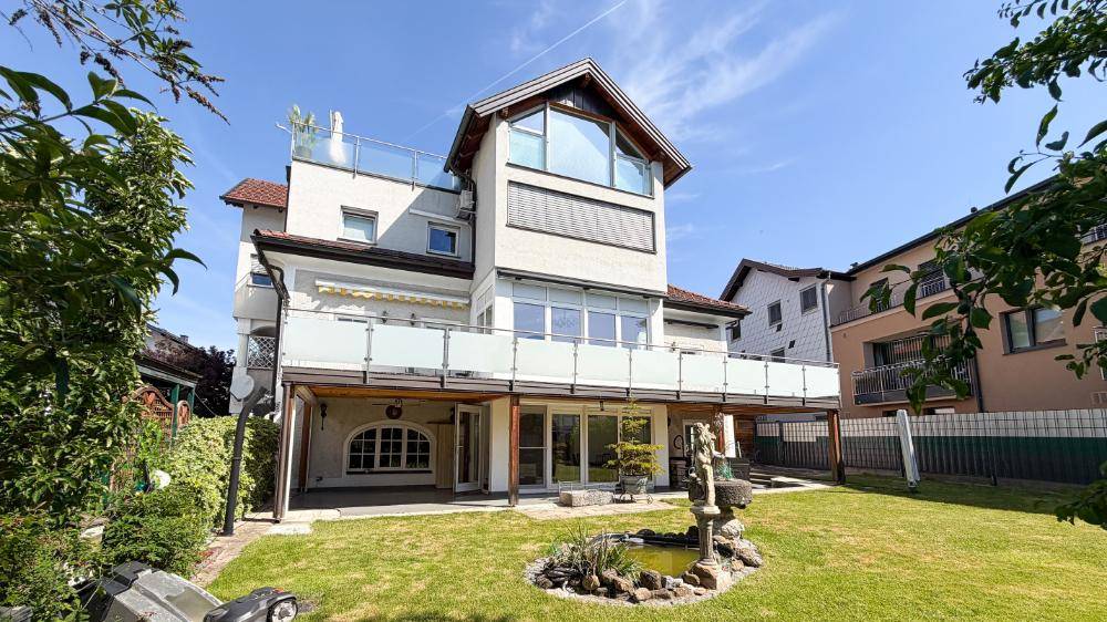 Rückansicht des Hauses mit großem Garten, Terrasse und Wasserspiel.