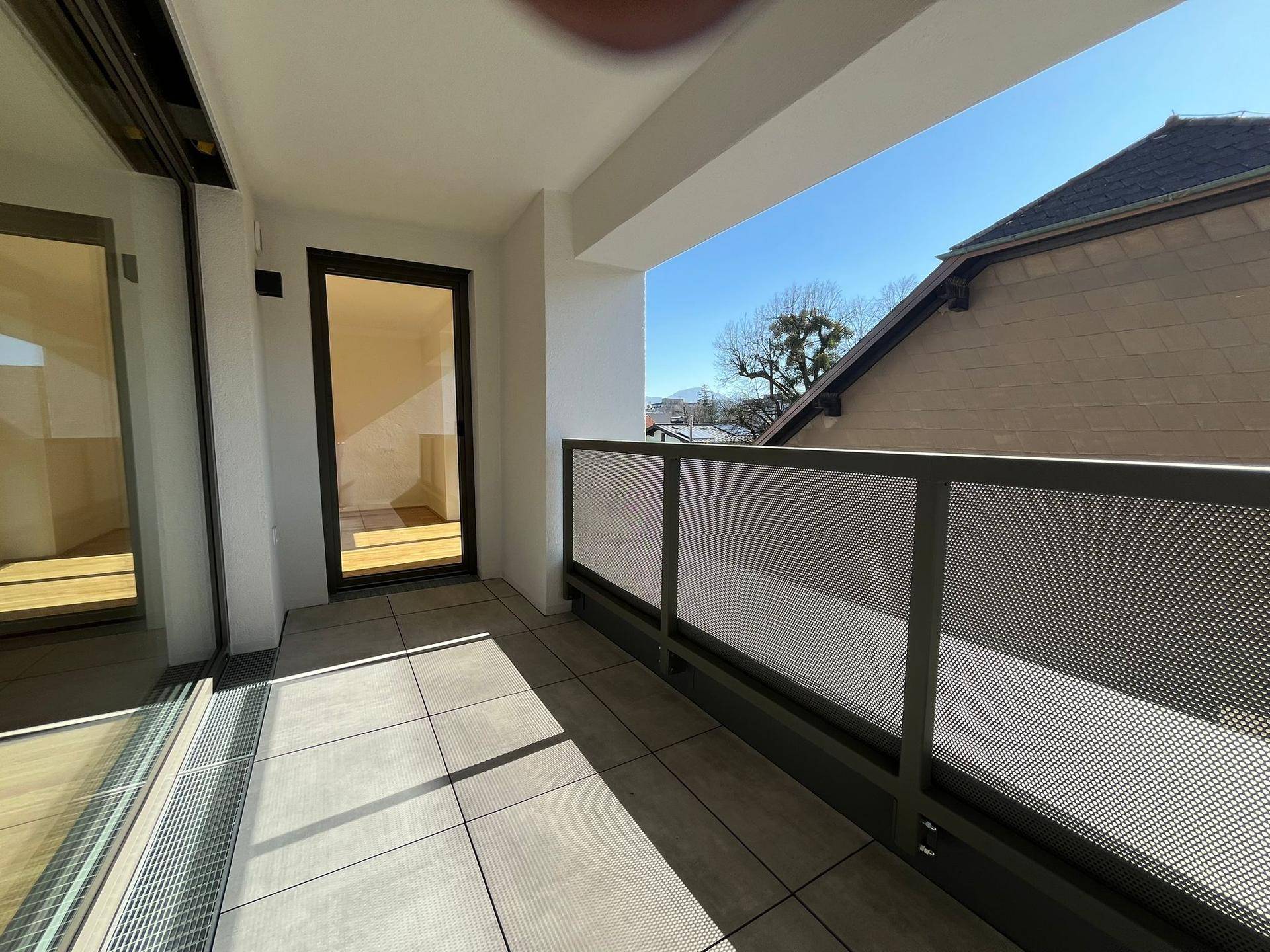 Geräumiger Balkon mit Fliesenboden und moderner Metallbrüstung, bietet Platz im Freien.