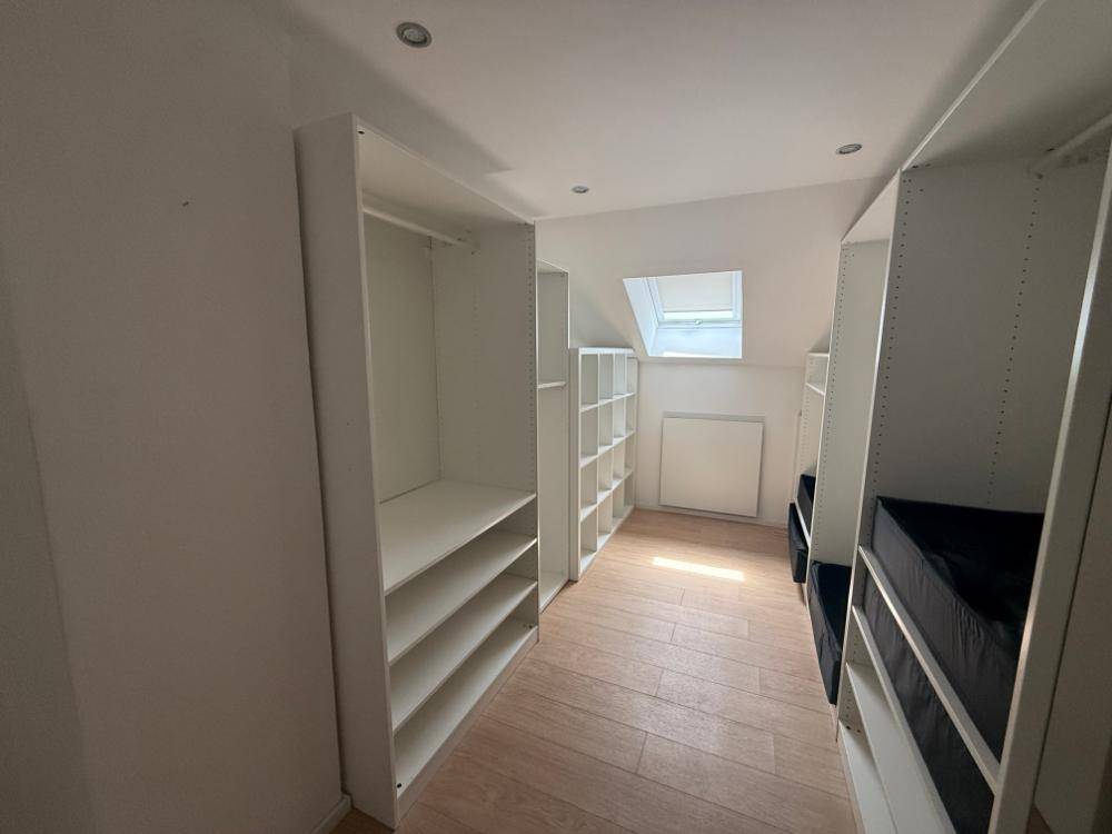 Begehbarer Kleiderschrank im Dachgeschoss mit Regalsystemen und Dachfenster.