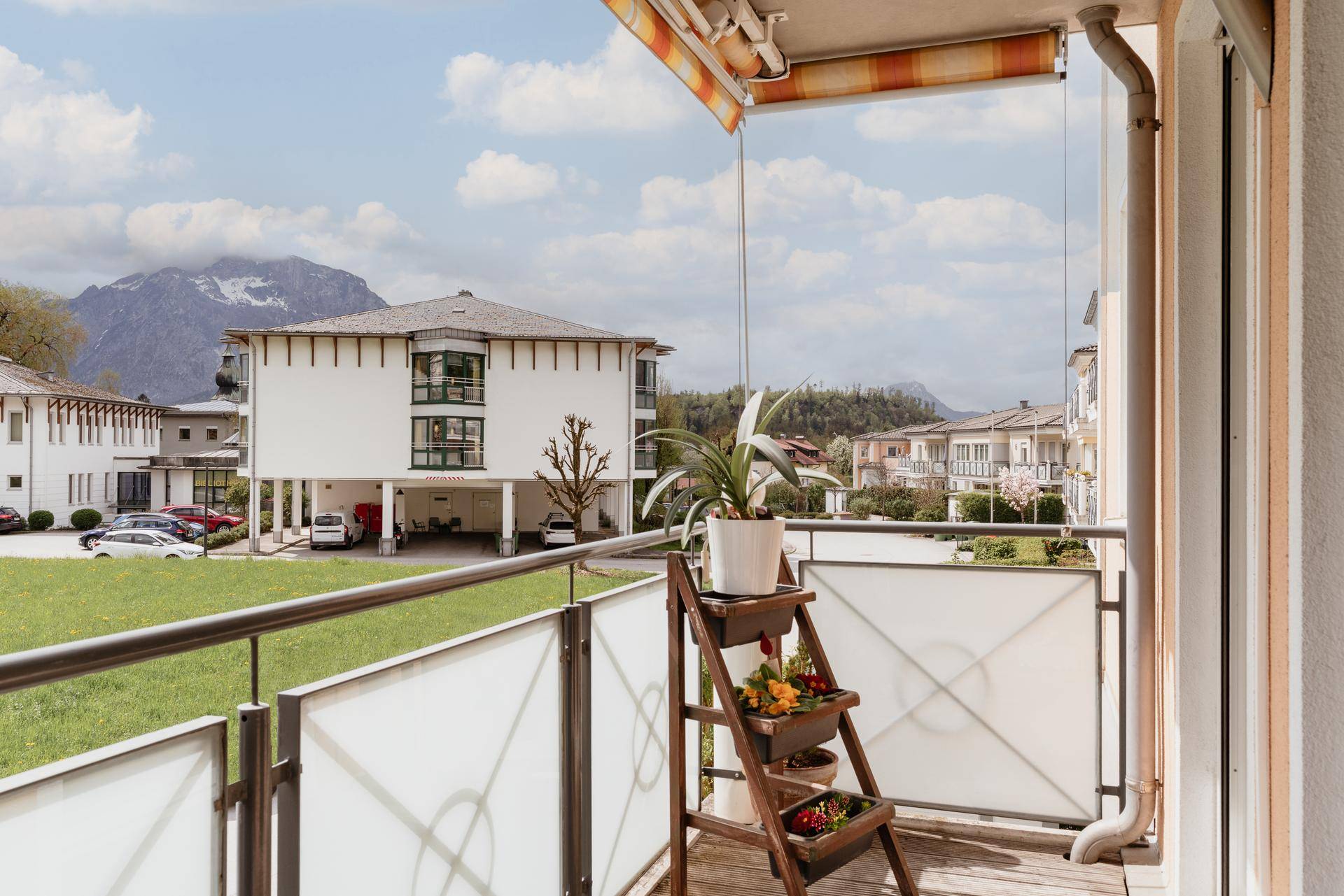 Balkon mit Bergblick, Pflanzen und Markise für sonnige Tage.