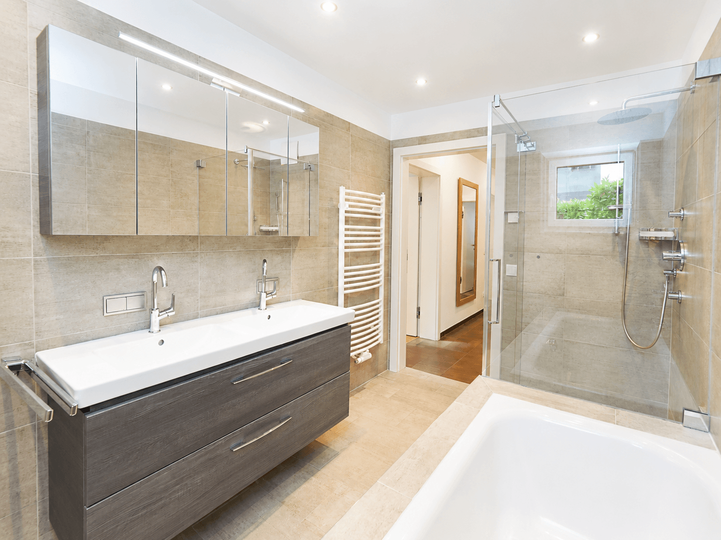 Geräumiges Badezimmer mit Doppelwaschbecken, Spiegelschrank, Dusche und Badewanne für höchsten Komfort.