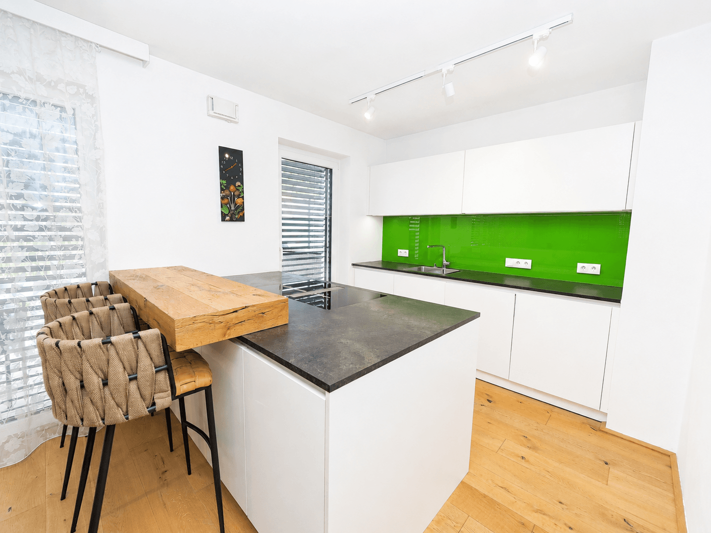 Moderne Küche mit Kochinsel, Frühstücksbar und Induktionskochfeld, ideal für geselliges Kochen.