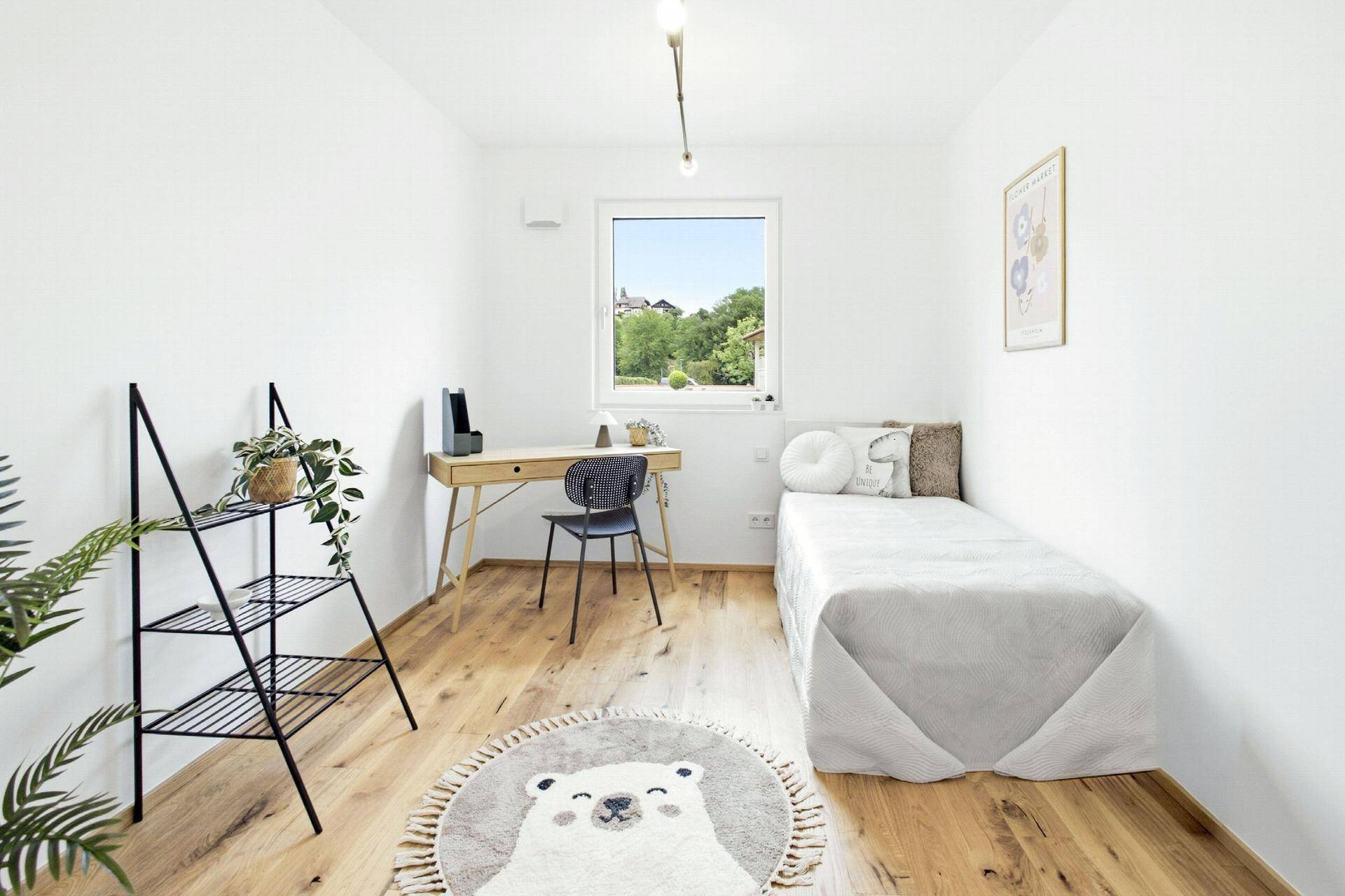 Kinderzimmer oder Gästezimmer mit Einzelbett, Schreibtisch und Holzboden.