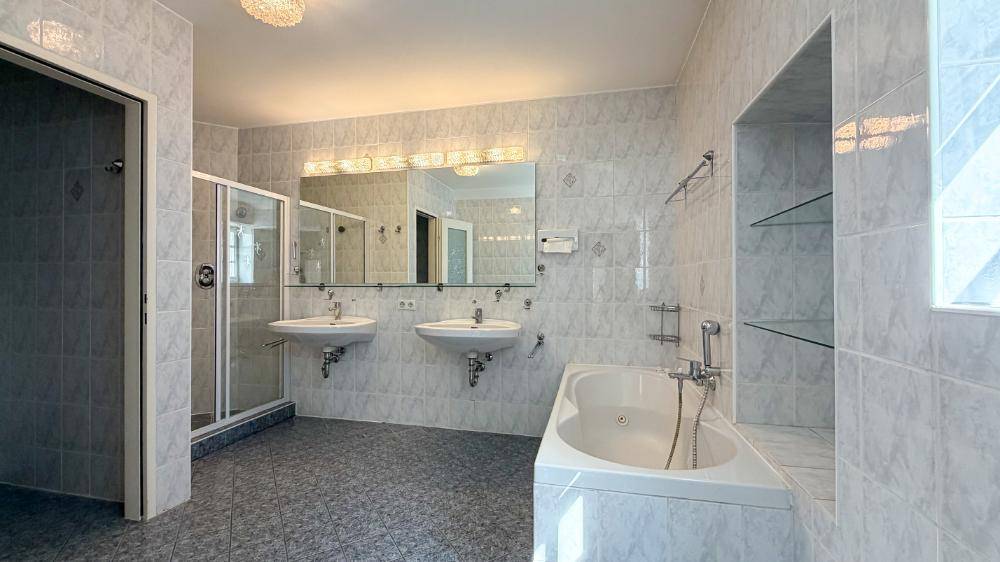Geräumiges Badezimmer mit Doppelwaschbecken, Dusche und Badewanne.