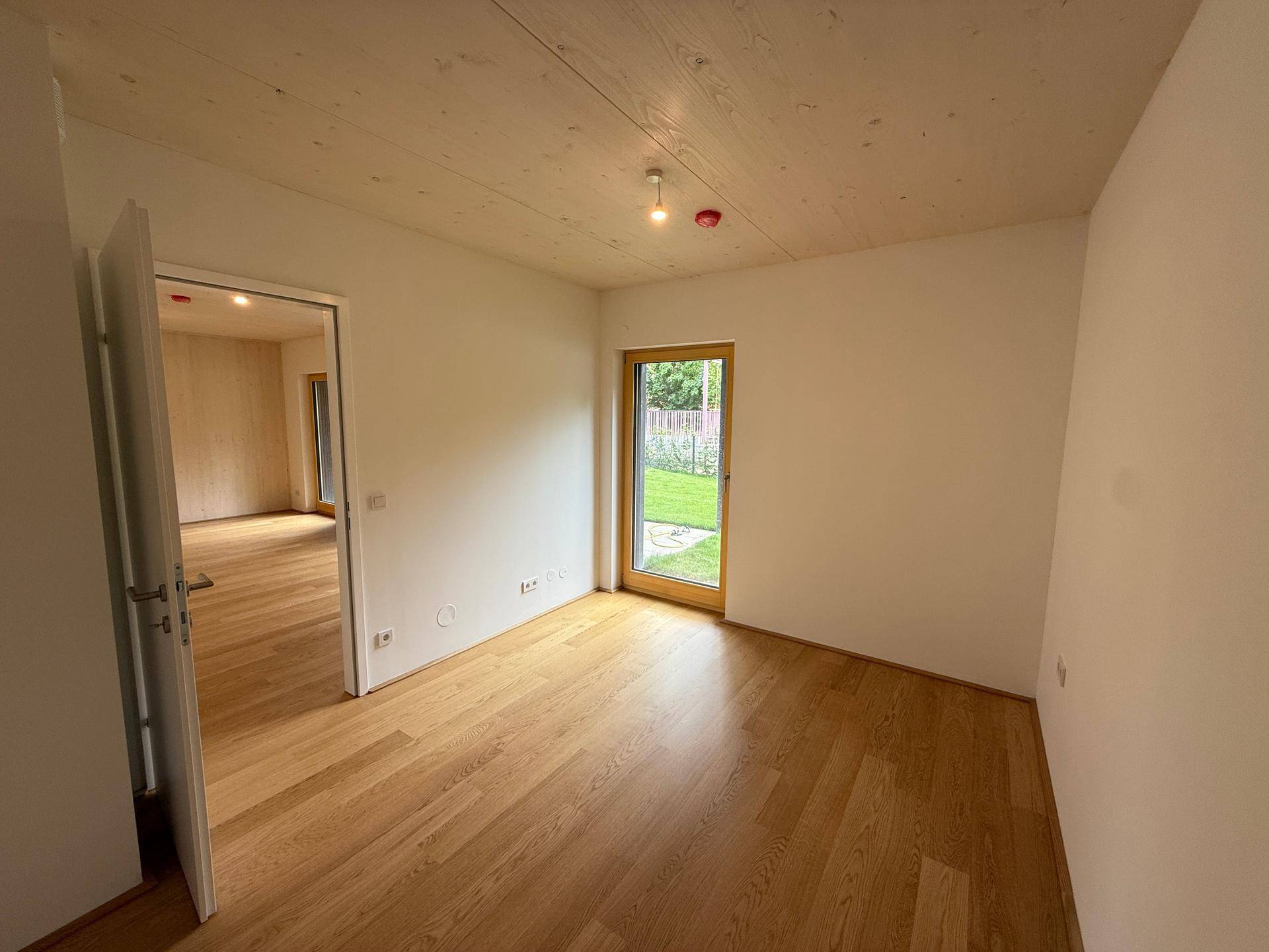Gemütliches Zimmer mit Eichenparkett, Holzbalkendecke und direktem Zugang zum Garten.