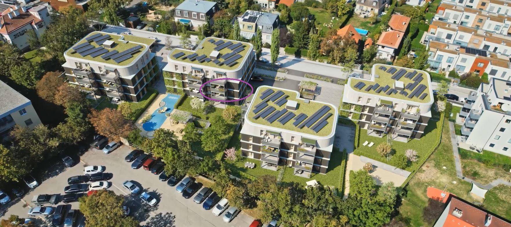 Luftaufnahme moderner Wohngebäude mit Gründächern und Photovoltaikanlagen in grüner Umgebung.