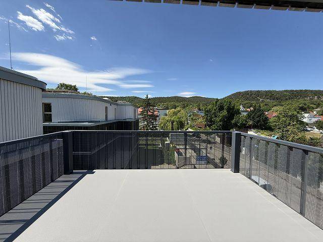 Geräumige Dachterrasse mit moderner Metallbrüstung und weitem Blick über die Landschaft.