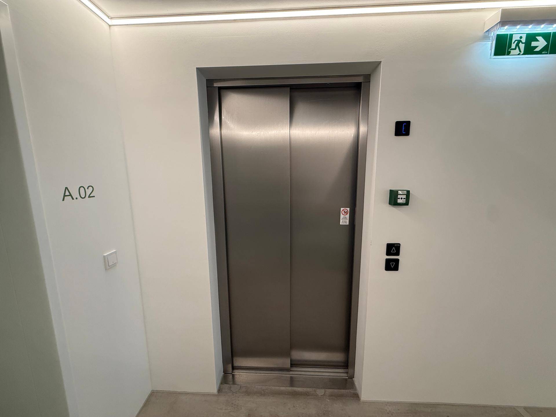 Moderner Aufzug in einem hellen Flur mit Zugang zu den Wohneinheiten.