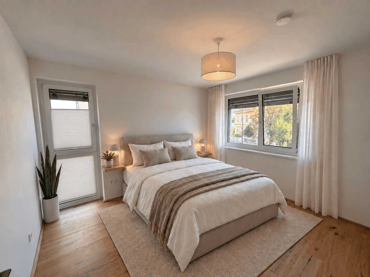 Gemütliches Schlafzimmer mit Doppelbett, Holzboden und direktem Zugang zu einem Balkon oder einer Terrasse.