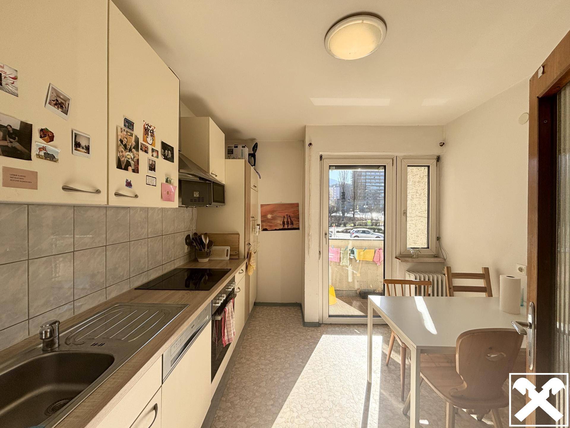 Helle Küche mit Essbereich und direktem Zugang zum Balkon, ideal für Mahlzeiten im Freien.