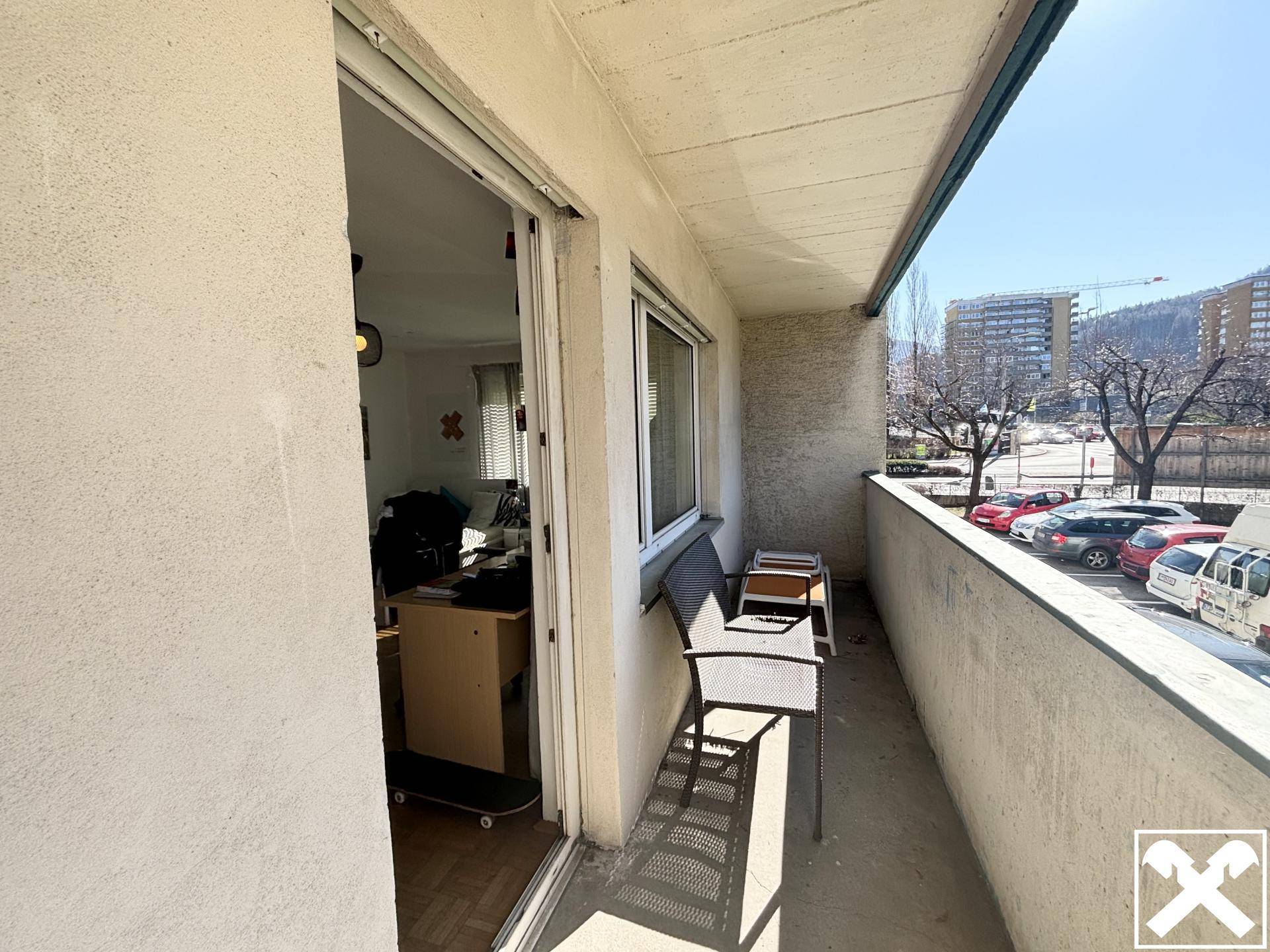 Sonniger Balkon mit Sitzgelegenheiten und Blick auf die Umgebung, ideal zum Entspannen.