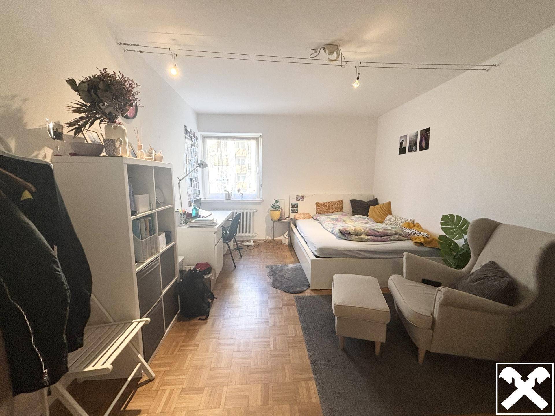 Modern eingerichtetes Schlafzimmer mit Parkettboden, bequemen Möbeln und viel natürlichem Licht.