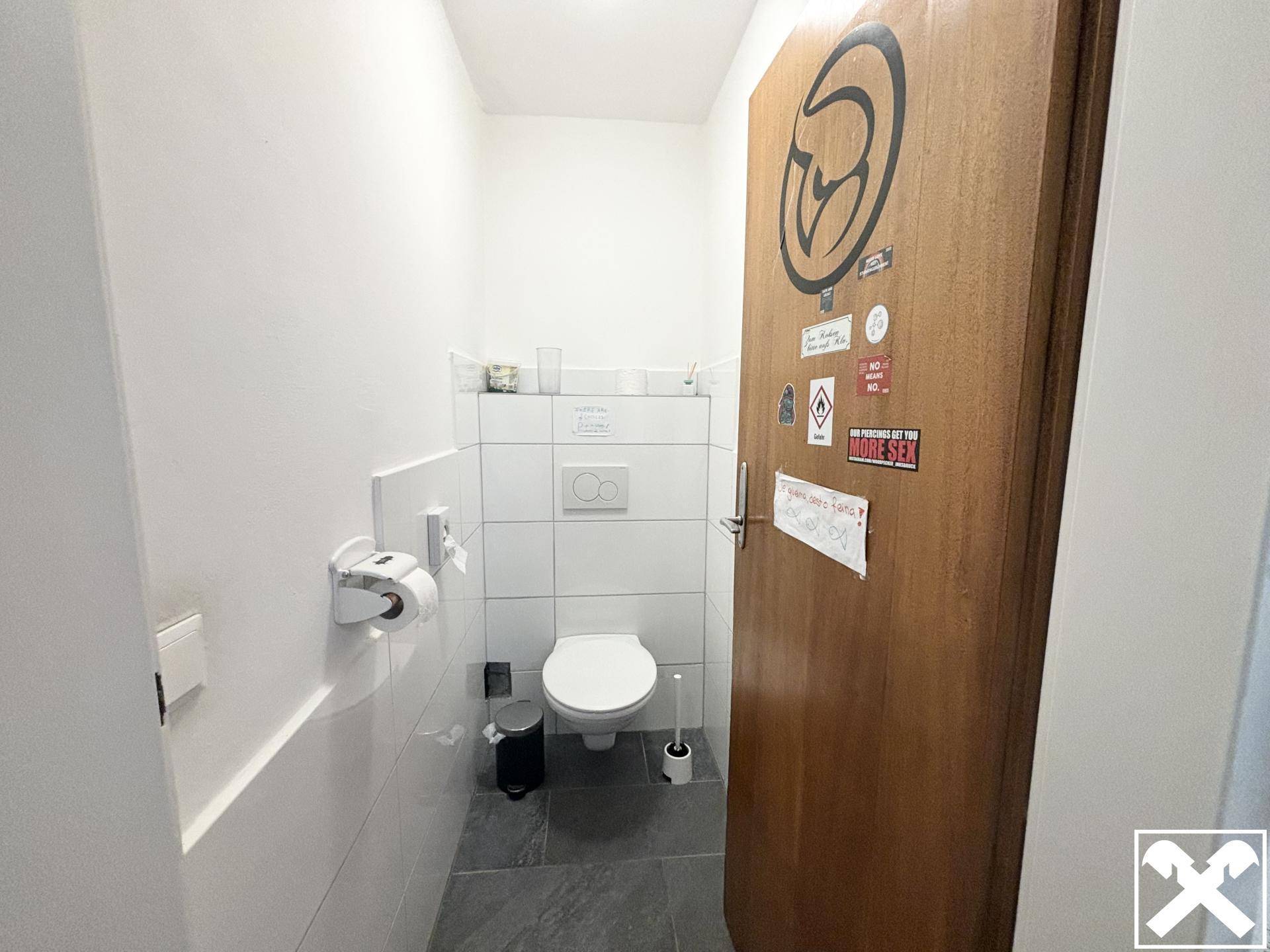 Separate Gästetoilette mit Wand-WC und modernen Fliesen, funktional und sauber.