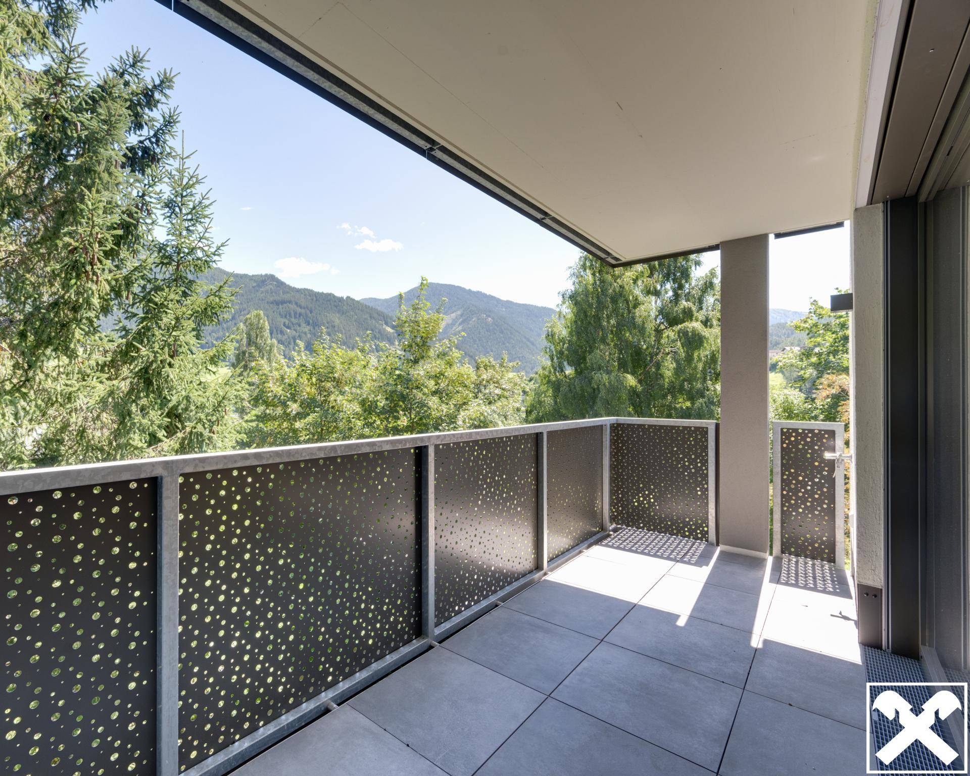 Geräumiger Balkon mit Fliesenboden und modernem Geländer, bietet einen weiten Bergblick.