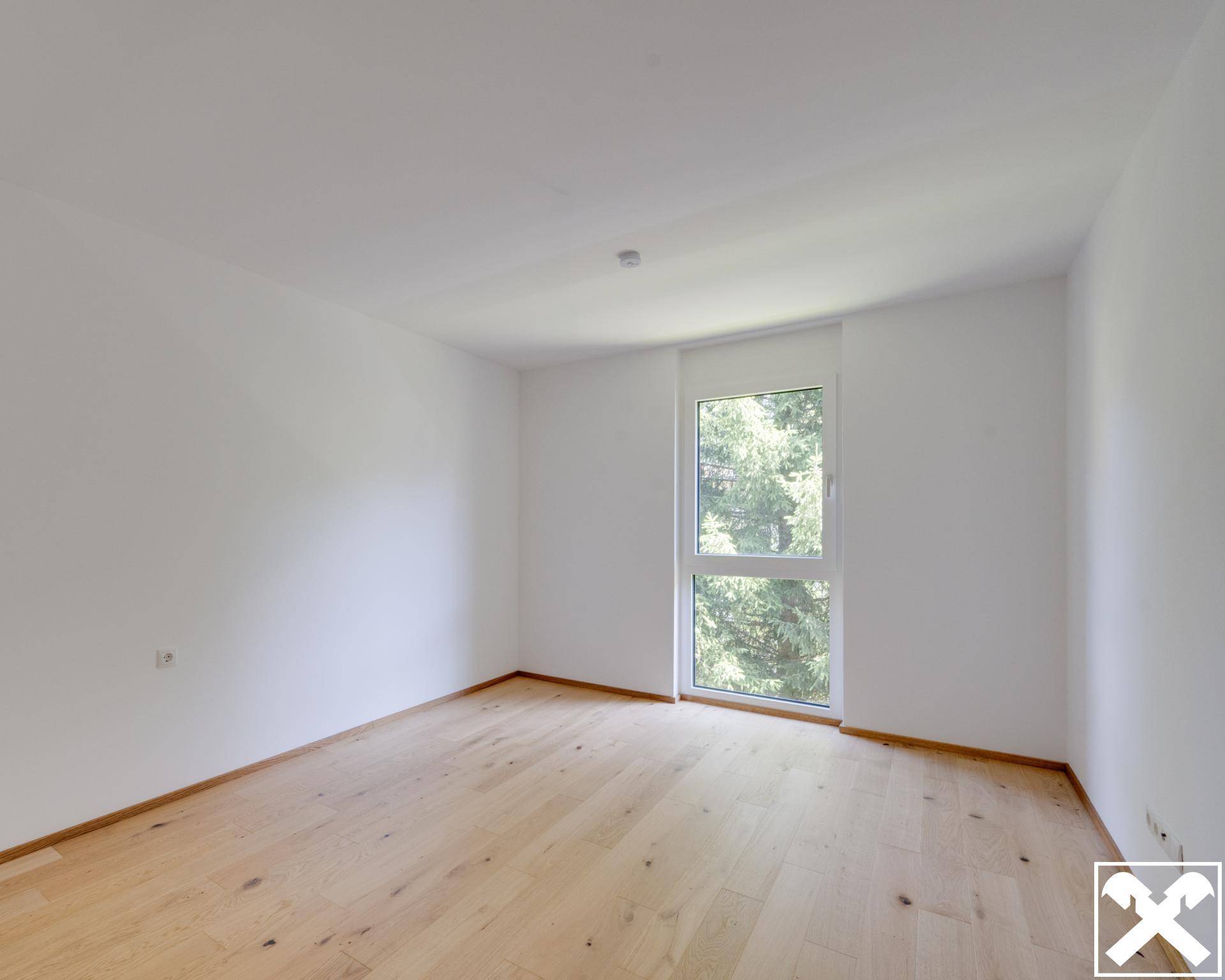 Weiteres helles Zimmer mit Holzboden und Fenster, ideal als Schlaf- oder Arbeitszimmer nutzbar.