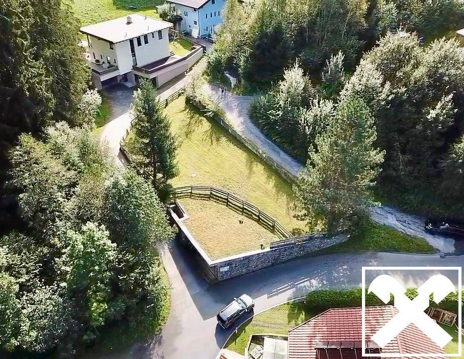 Übersicht aus der Vogelperspektive auf ein Grundstück mit Zufahrtswegen und umliegender Natur.