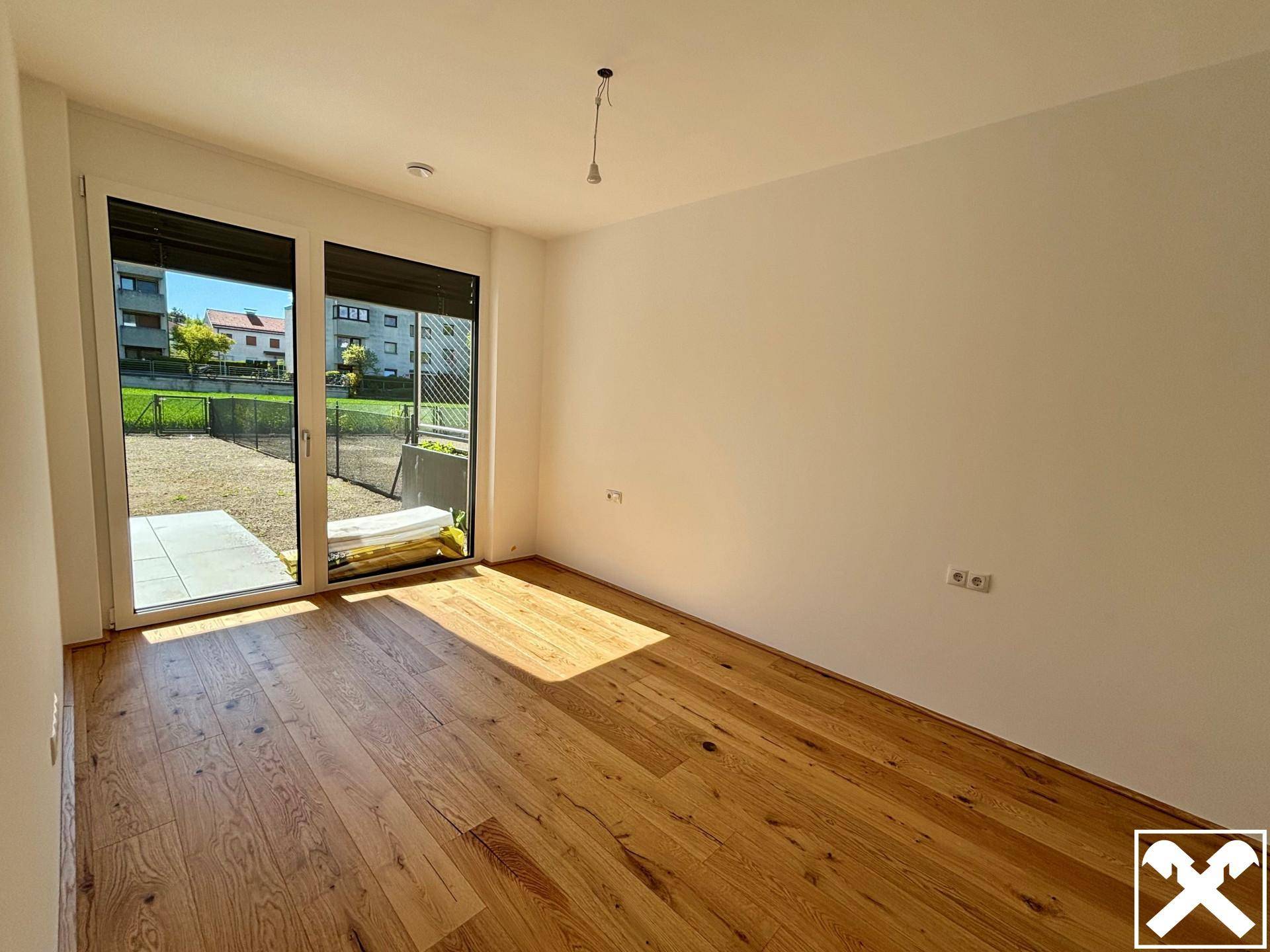 Helles Schlafzimmer mit Holzboden und direktem Zugang zum Außenbereich.