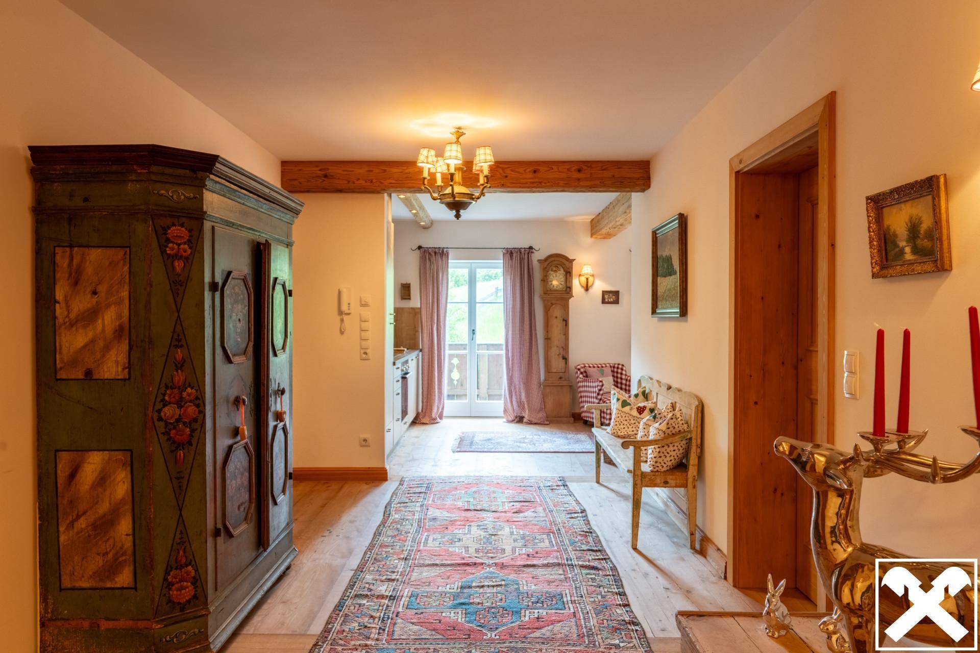 Heller Flur mit traditionellen Möbeln und Holzbalken, führt zu weiteren Räumen und Ausgang.