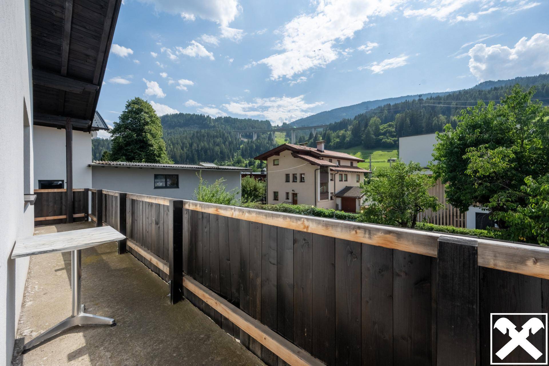Balkon mit Holzboden und Geländer, bietet einen weiten Blick auf die umliegende Landschaft.