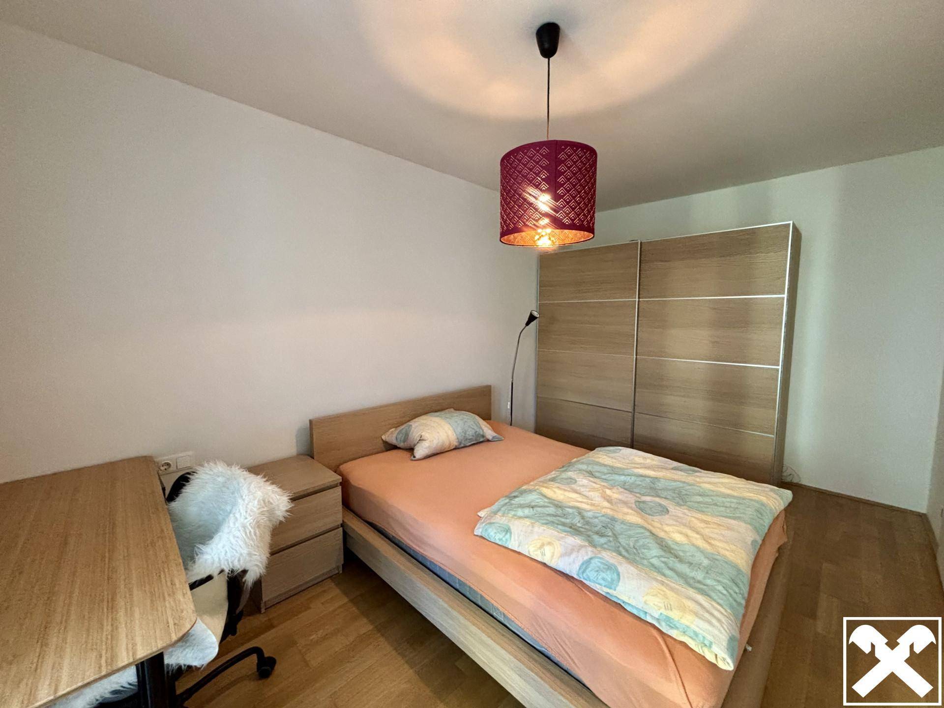 Gemütliches Schlafzimmer mit Einzelbett, Schreibtisch und großem Holzschrank, ideal für Gäste oder Kinder.