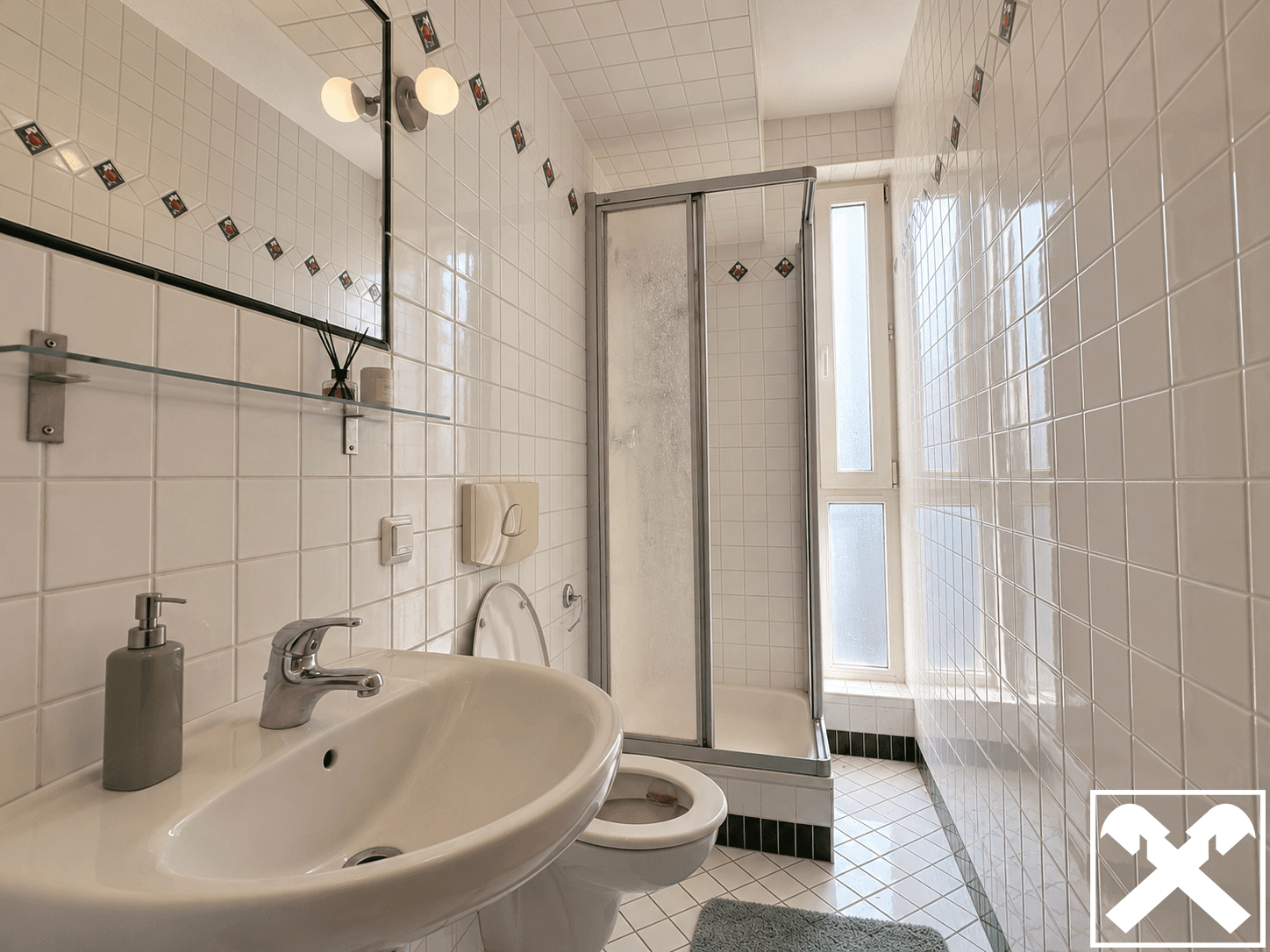 Funktionales Badezimmer mit Duschkabine, Waschbecken und Fenster, komplett gefliest.