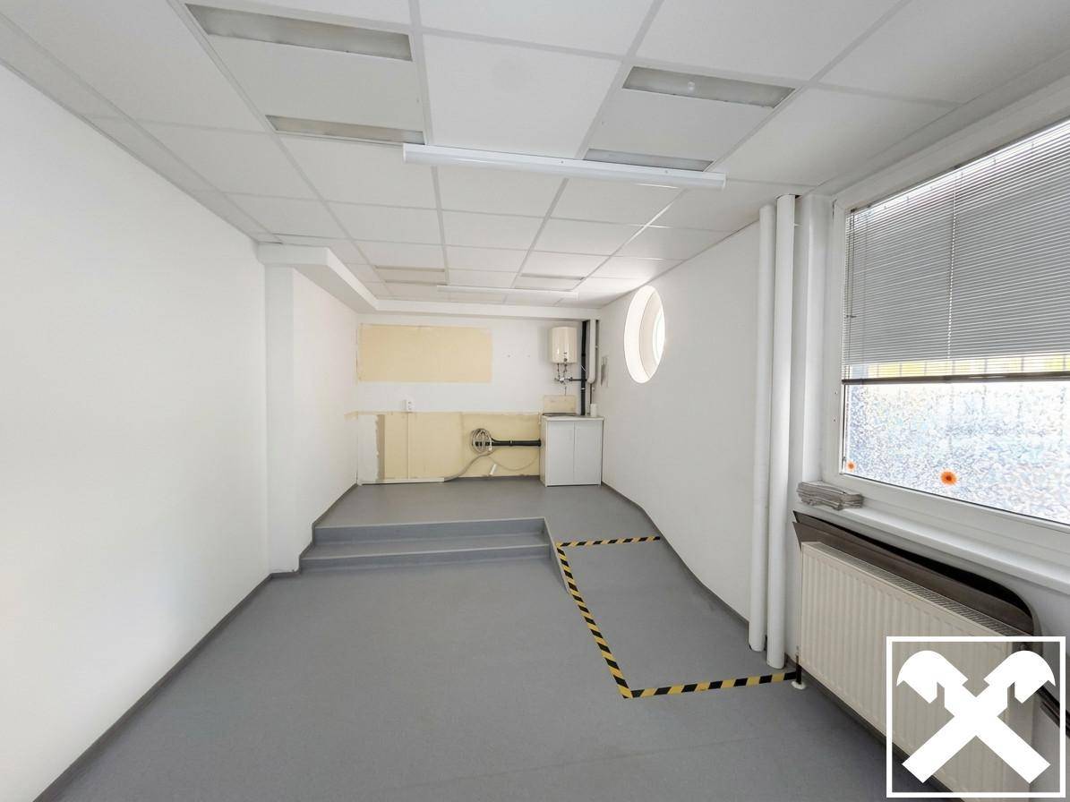 Funktionsraum mit kleiner Küchenzeile, Warmwasserbereiter, Fenster und einer Rampe für Barrierefreiheit.