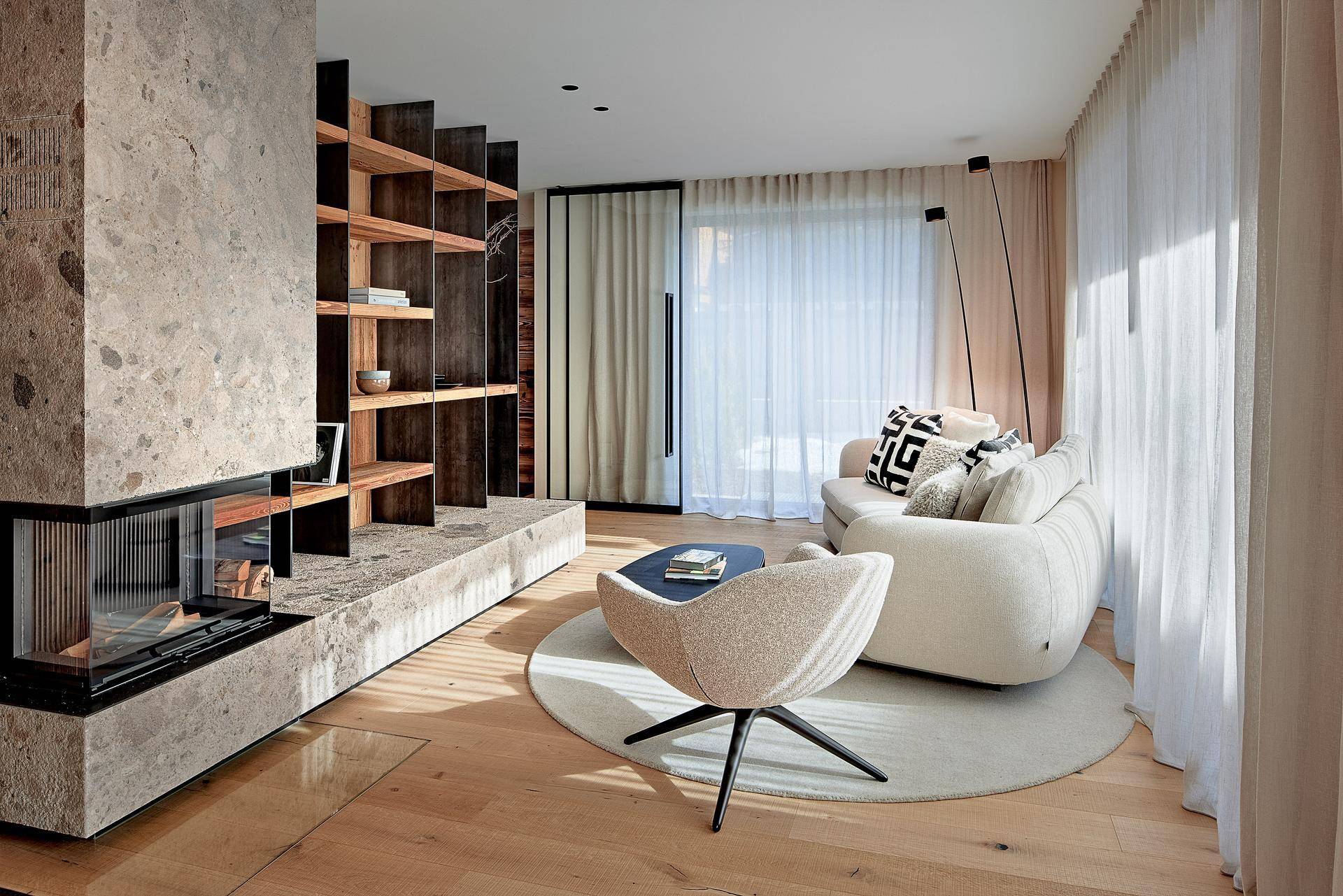 Gemütliches Wohnzimmer mit Kamin, bequemer Couch und Holzboden.