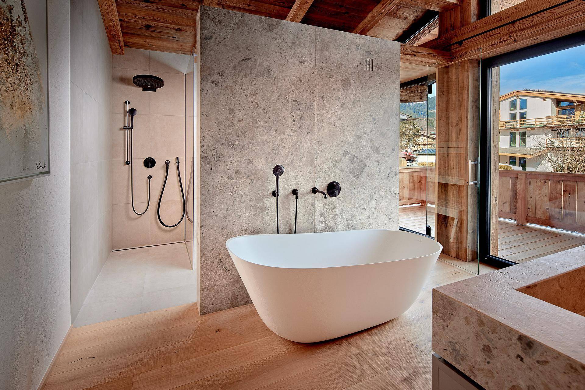 Luxuriöses Badezimmer mit freistehender Badewanne, begehbarer Dusche und Bergblick.