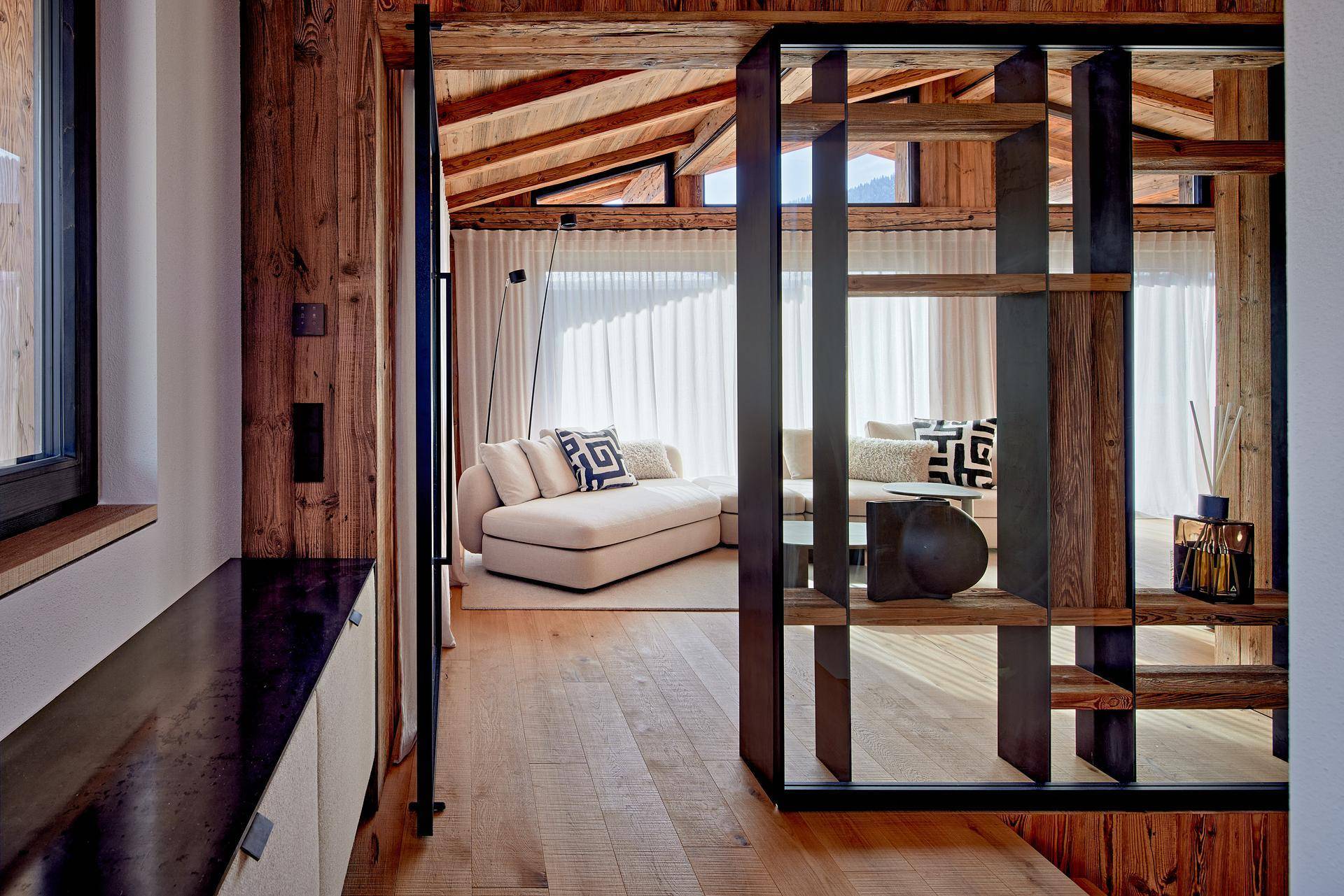 Heller Flur mit Holzböden und einem modernen Regal, der zum Wohnbereich führt.