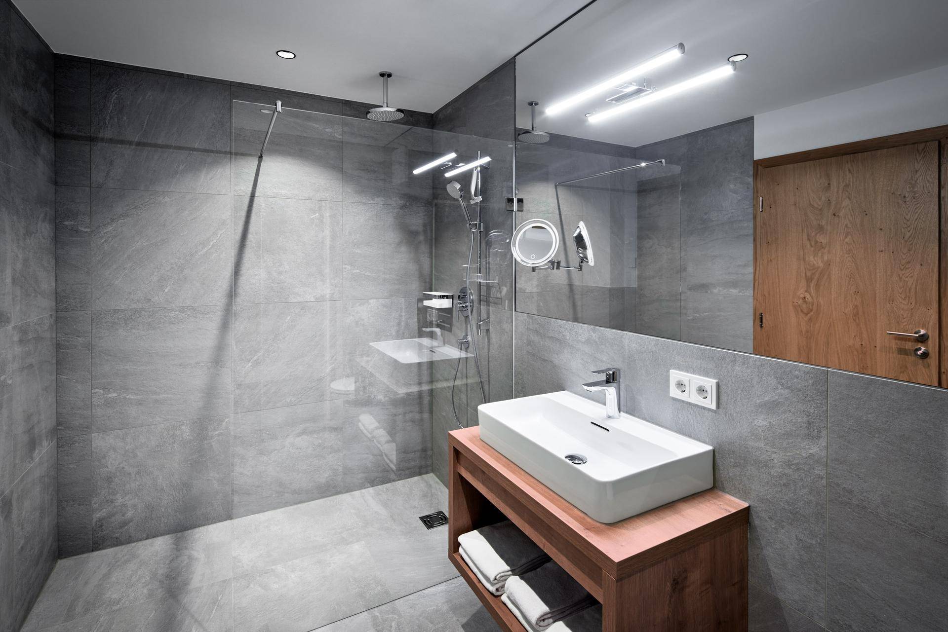Geräumiges, modernes Badezimmer mit großer begehbarer Dusche und elegantem Einzelwaschbecken.