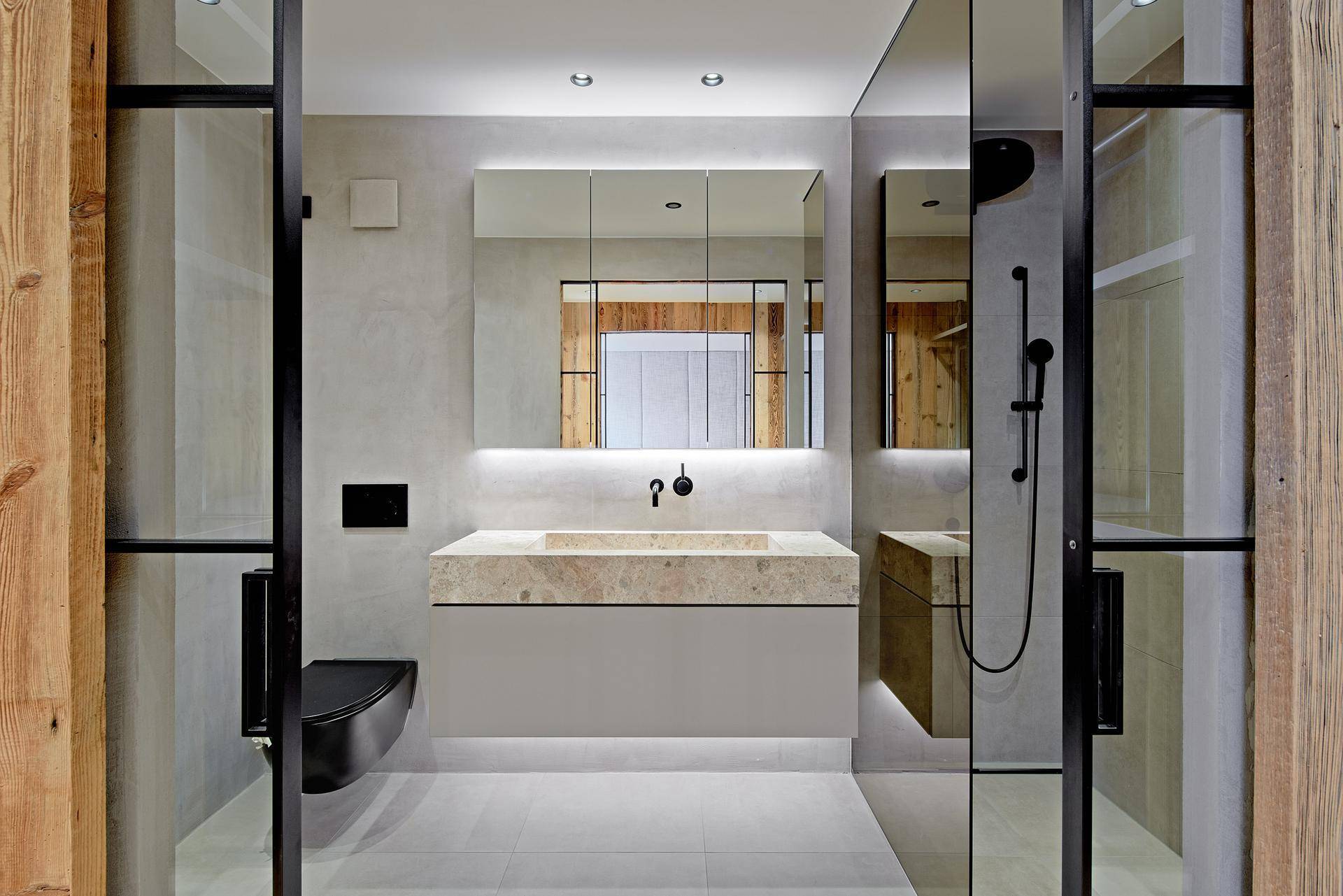 Modernes Badezimmer mit Waschbecken, Wand-WC und Spiegelschrank.