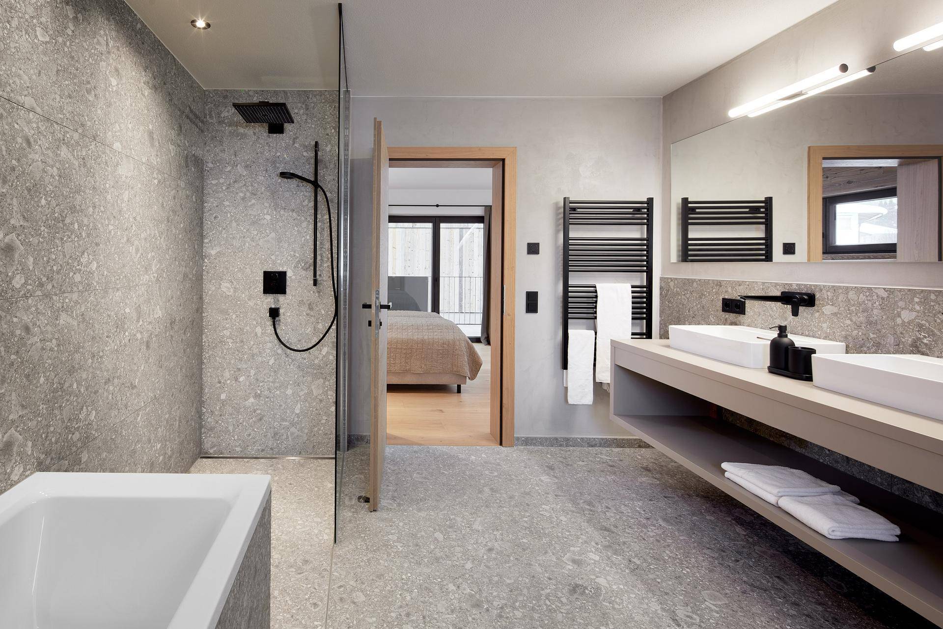 Elegantes Badezimmer mit Badewanne, begehbarer Dusche und Doppelwaschbecken.