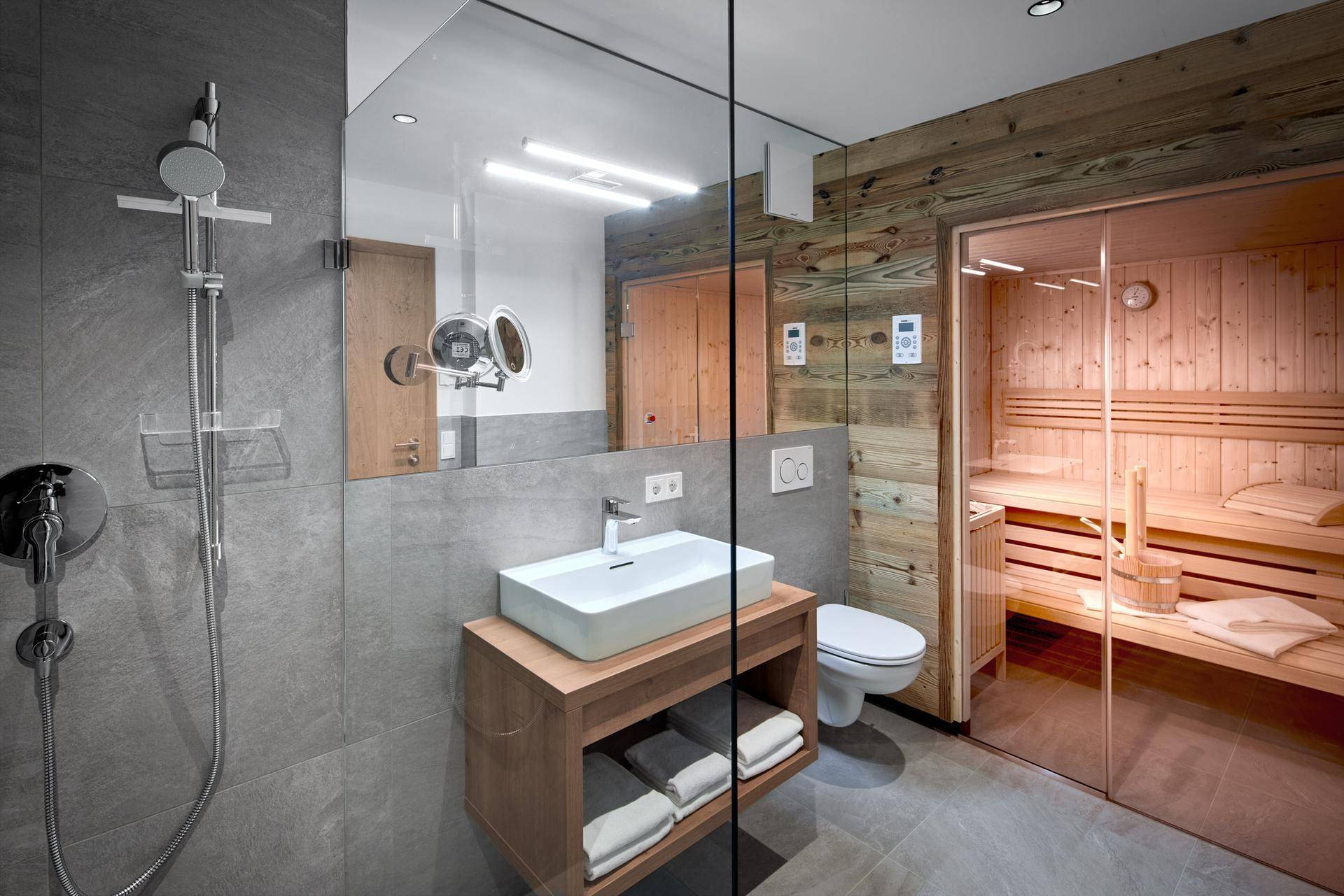 Modernes Badezimmer mit begehbarer Dusche, Einzelwaschbecken und integrierter Sauna für Wellness.