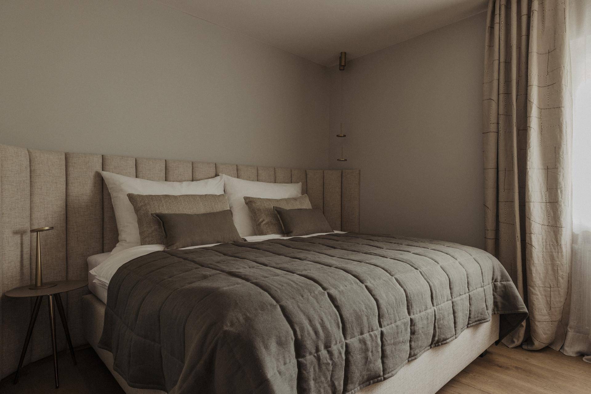 Gemütliches Schlafzimmer mit großem Doppelbett, weichen Textilien und natürlichem Lichteinfall.