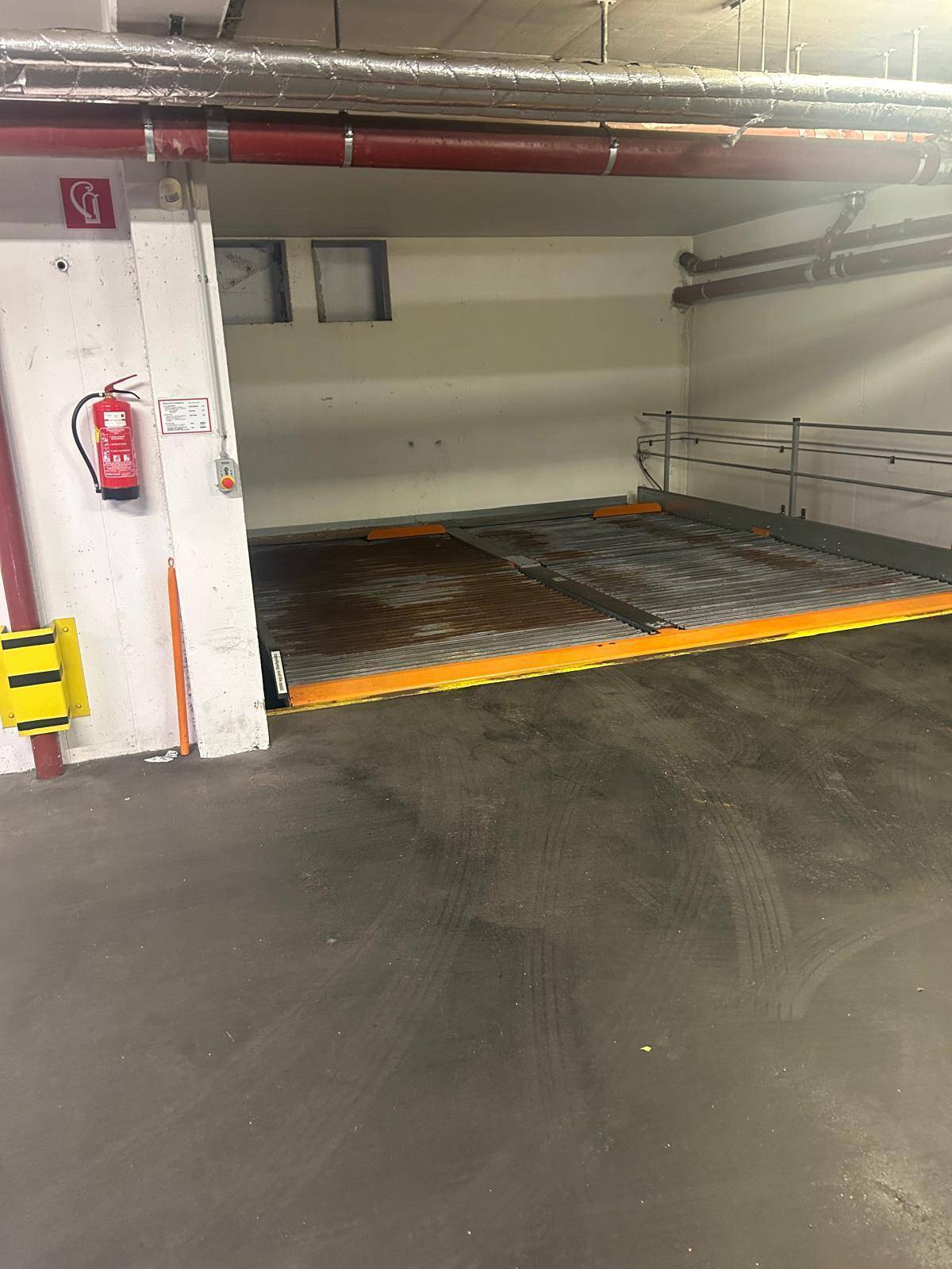 Breitere Ansicht eines Tiefgaragenstellplatzes mit Doppelparker-System und Brandschutzvorrichtungen.