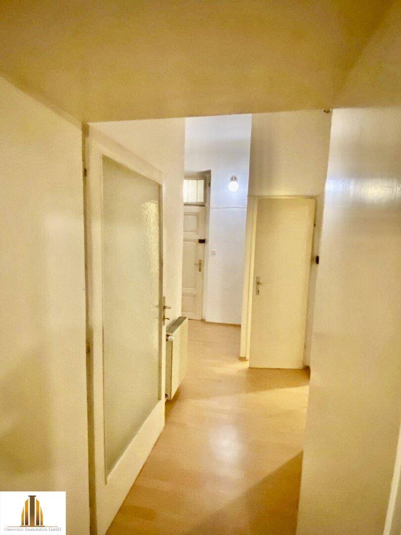 Heller Flur mit Holzboden und mehreren Türen, verbindet verschiedene Räume der Wohnung miteinander.