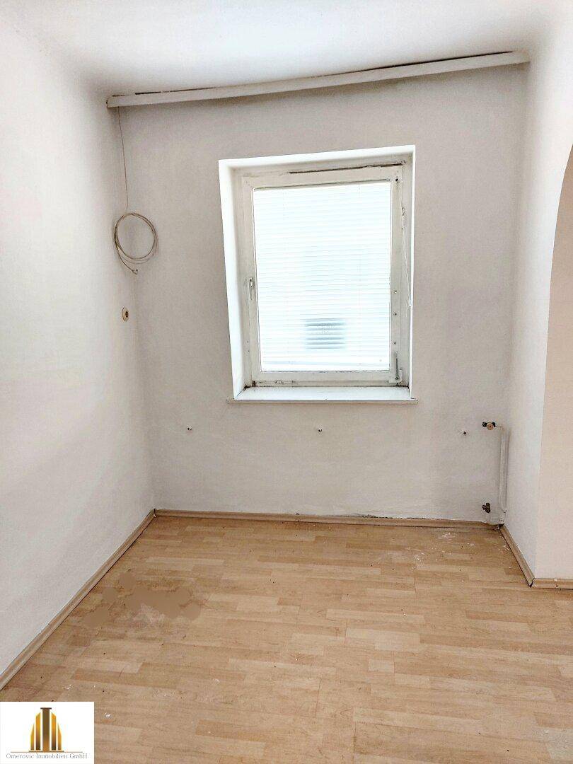 Kleines, helles Zimmer mit Parkettboden und einem Fenster, ideal als Schlaf- oder Arbeitszimmer.