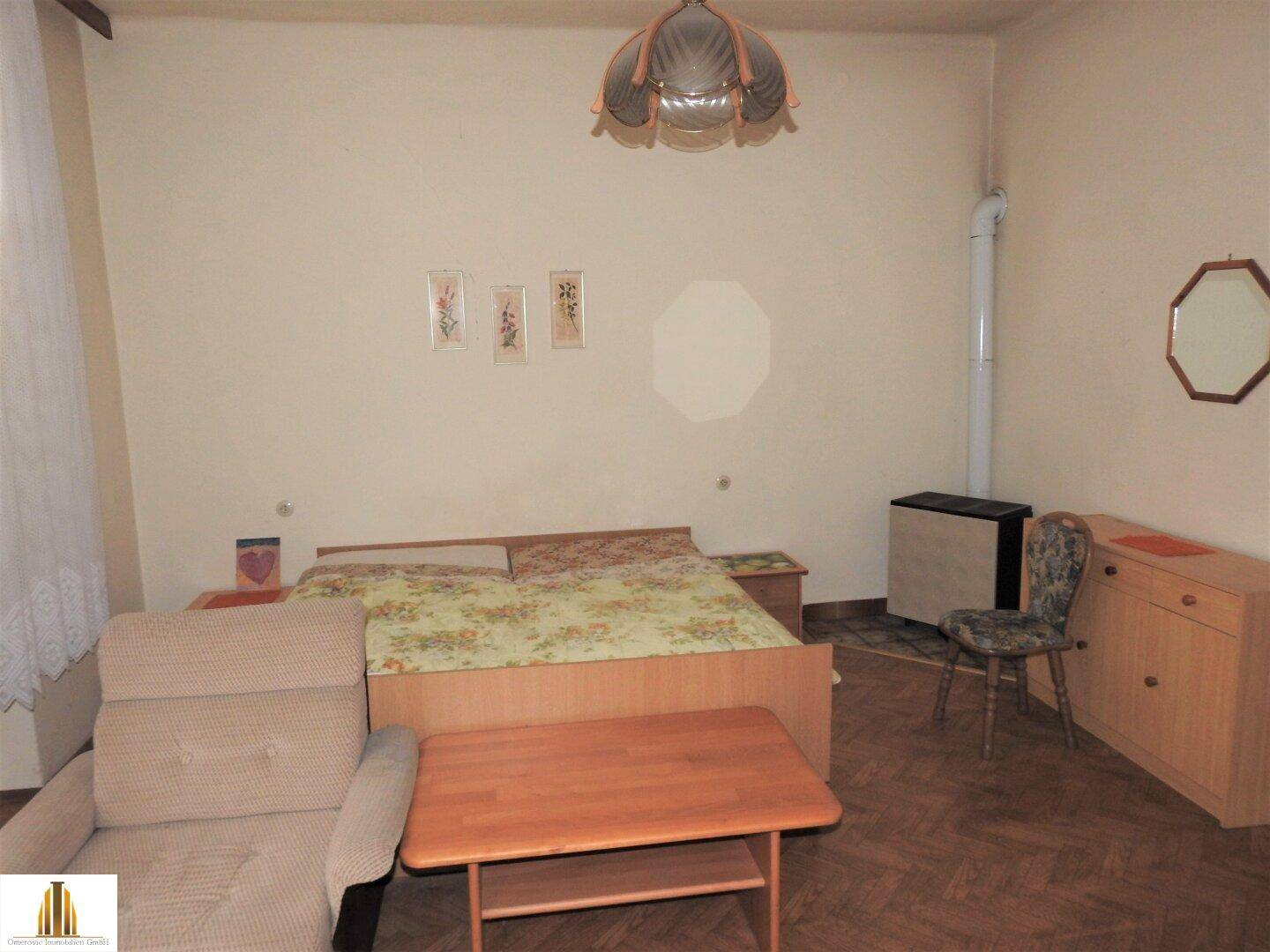 Schlafzimmer mit Doppelbett, Nachttischen und einem kleinen Tisch, ausgestattet mit Holzmöbeln.